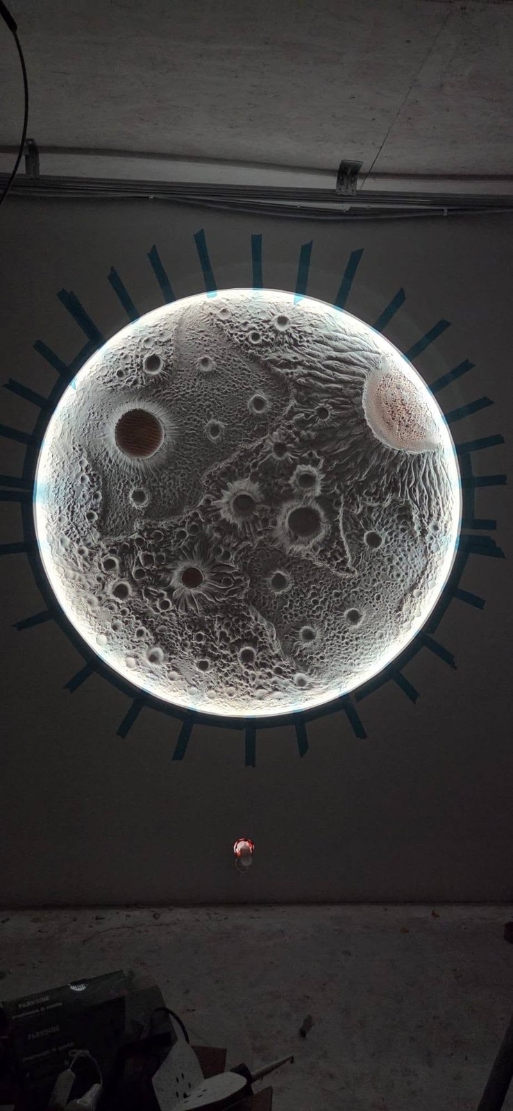 Gros plan sur le décor lunaire rétroéclairé, en cours de réalisation.